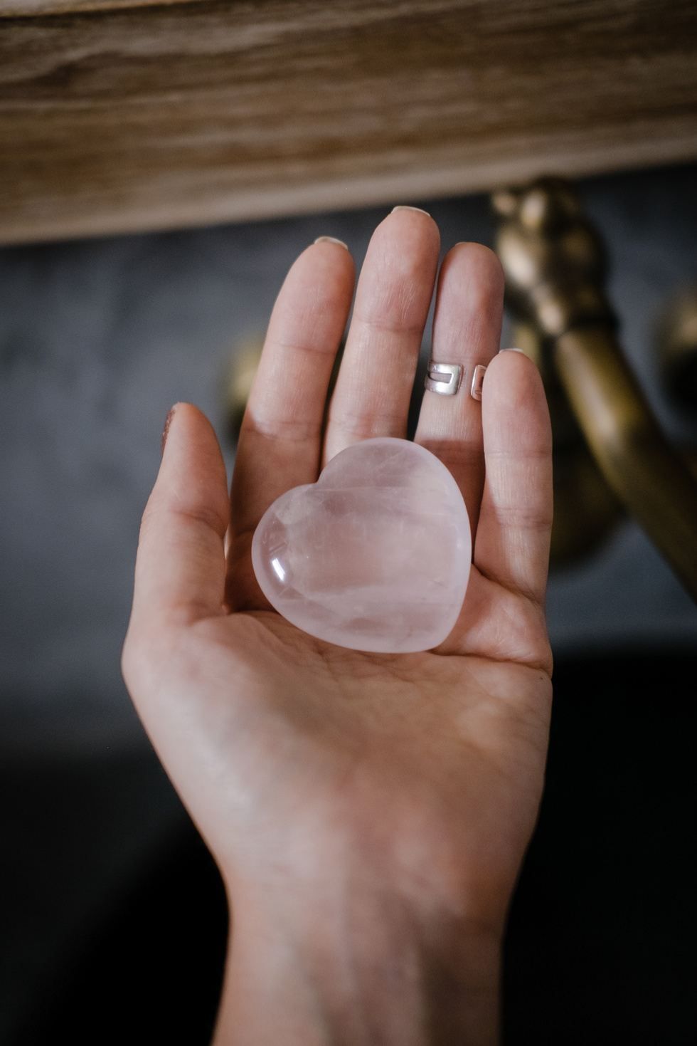 Woman holds rose quartz heart crystal